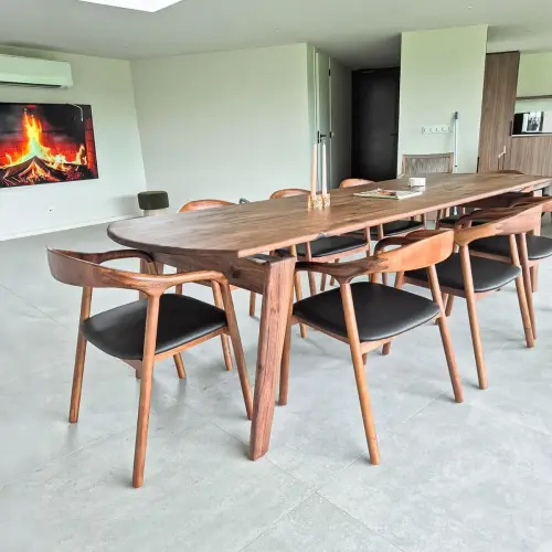 Artson notenhouten eettafel met bijpassende eetkamerstoelen, samengesteld in de showroom, in een modern interieur in Hengelo.